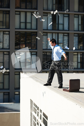 Image of Business, financial freedom and money rain with a man in the city, throwing cash during a summer day. Finance, success or raining dollars with an employee on the roof of a building in an urban town