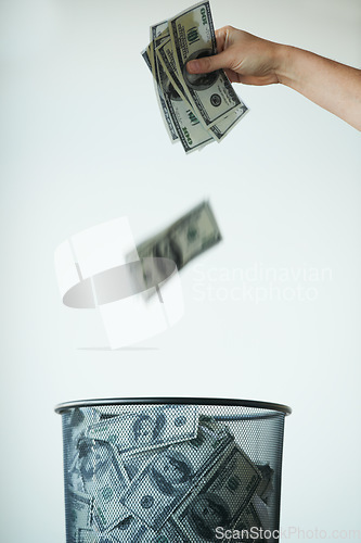 Image of Bin, money or bills with finance, inflation or debt with bankruptcy, trash or global recession. Waste bucket, cash or economy issues with fraud, corruption or value decline on a studio background