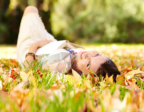 Image of Portrait, book and woman relax in park with novel in nature learning for education as student outdoor on campus. University, portrait and young person with textbook on grass field for scholarship