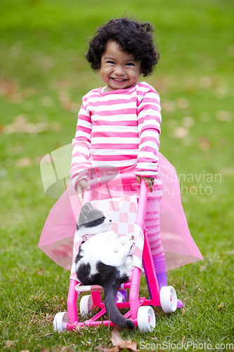 Image of Portrait, happy kid and kitten for playing with baby carriage on grass, garden or backyard of family home. Little girl, pet and pushing of stroller together for fun, imagine or game for bond by care