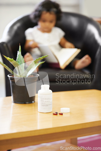 Image of Pills, bottle and young child reading for adhd diagnosis, school work learning or education. Medication, capsules or daughter or book concentration in home development discipline, childhood or growth