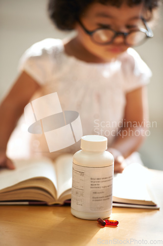 Image of Girl, child and reading or book concentration or pill bottle adhd diagnosis, learning or development. Kid, glasses and childhood story knowledge discipline, medical pills capsules or school thinking