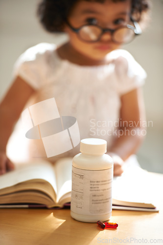 Image of Girl, child and reading or book pill bottle or adhd diagnosis, learning or development. Kid, glasses and childhood discipline story knowledge concentration, medical capsules or thinking at school