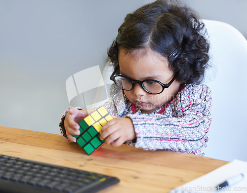 Image of Smart, rubix cube and a child for playing, learning and strategy with color at a desk. House, clever and a girl, young kid and a baby with toys for thinking, psychology development and a solution