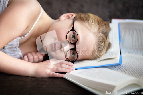 Image of Portrait, learning and a child reading a book for knowledge, studying or to relax on the floor. Library, young and a girl, kid or a student at school with a novel, story or getting ready for an exam