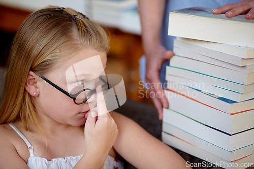 Image of Thinking, concern and a child with books at a library for education, knowledge and learning. Looking, worry and a girl, kid and librarian with textbooks for studying, hobby or homework at school