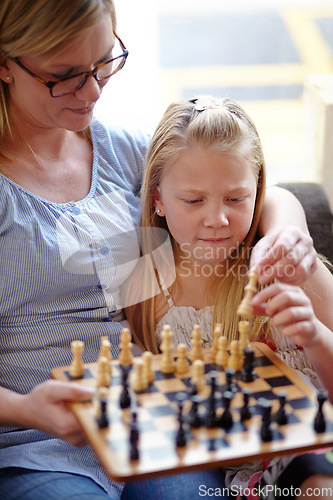 Image of Thinking, chess and mother and child with board for education, teaching and making a move. Family, house and a mom, girl kid and a competition for a hobby, playing and learning a skill while bonding