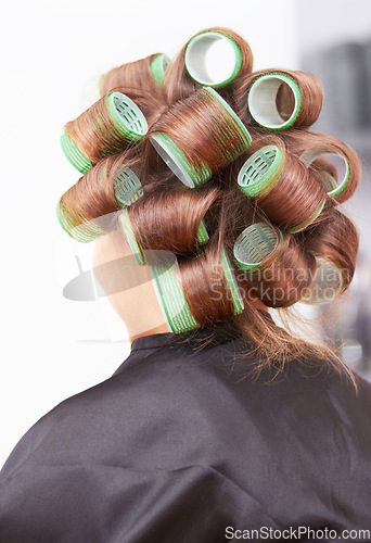 Image of Hair care, woman in salon with curlers for beauty and luxury hairstyle at professional service from back. Haircare, rollers and girl at hairdresser with tools for wellness, color and style at spa.