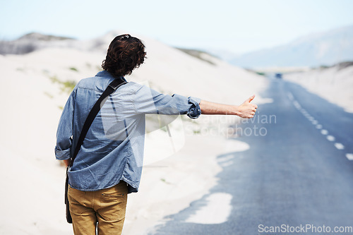 Image of Back, man or hitchhiker in nature on road for travel, destination or road trip with thumbs up in street. Rear View, person or hand gesture outdoor or hitchhiking, transportation and waiting in summer