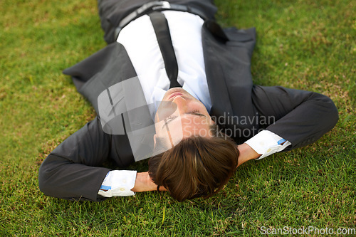 Image of Relax, grass and a business man lying on a field outdoor from above for the success of a completed task. Sleep, dreaming or rest with a corporate employee chilling at a garden or park in summer