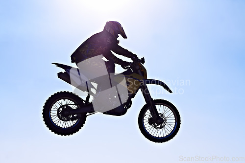Image of Man, motorcycle or bike jump air as professional rider in danger competition, fearless or race. Male person, off road transportation or fast speed dirt adventure or rally, challenge or extreme sport