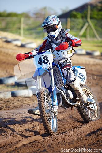 Image of Person, motorcycle and dirt race track adventure as .professional in action, danger or fearless risk. Bike rider, off road course and fast speed competition rally, extreme sport gear on sand path