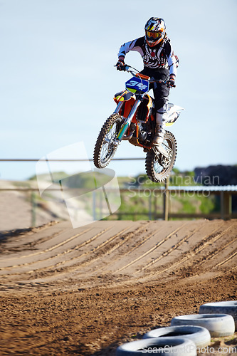 Image of Person, motorcycle or bike jump on race track as professional in action competition, fearless or dust path. Rider, off road transportation for fast speed adventure or rally, extreme sport or gear