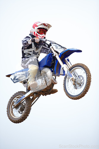 Image of Person, motorcycle and air jump in sky as professional in action, competition or fearless risk. Bike rider, off road transportation stunt or fast speed adventure at rally, extreme sport race or brave