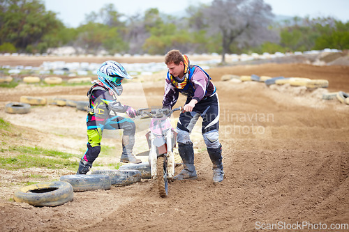 Image of Motorcycle, child and father help on dirt road, training and outdoor sports. Bike, kid and dad coaching rider, teaching and learning together at race, competition and mentor support on transportation
