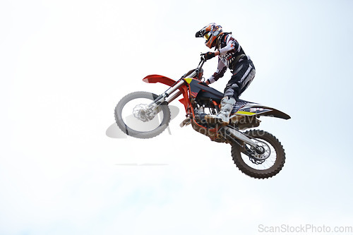 Image of Person, motorcycle and air jump adventure as professional in action, competition or fearless. Bike rider, off road transportation stunt or fast speed blue sky or rally, extreme sport or challenge