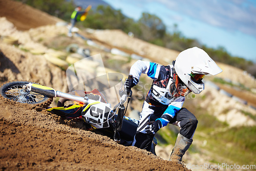 Image of Accident, fitness and man biker on a dirt road for competition, race or training workout. Sports, motorcycle and frustrated male athlete with mistake on bike in outdoor sand dunes or desert for hobby