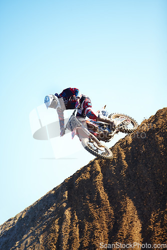 Image of Man, motorcycle and dirt bike on hill professional rider in action danger competition, fearless or race. Male person, transportation or fast mountain adventure or blue sky, rally challenge or driving