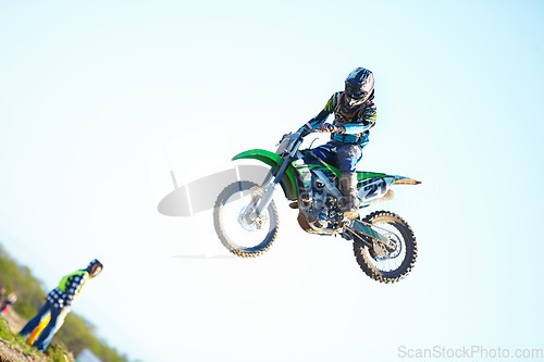 Image of Person, motorcycle and air stunt in blue sky as professional in action, competition or fearless. Bike rider, off road transportation jump or fast speed adventure at rally, outdoor challenge or race