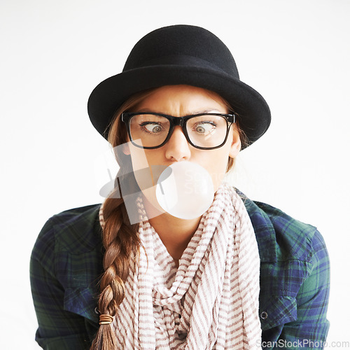 Image of Cool, gum and a woman blowing a bubble for comedy, funny and crazy on a white background. Comic, stylish and a goofy young girl with bubblegum, weird face and quirky on a studio backdrop with glasses