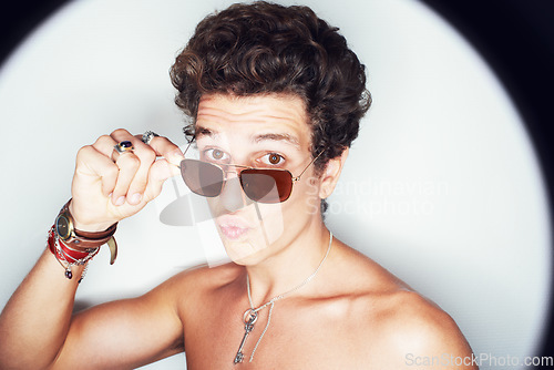 Image of Man, sunglasses and pout in studio portrait with spotlight for fashion, shirtless or style by white background. Person, emoji or kiss by halo for flirting, attitude or jewelry for trendy aesthetic