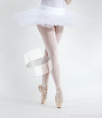 Image of Ballet dancer, legs and pointe shoes closeup in studio white background for performance, practice or balance. Female person, feet or tutu for artistic expression training, elegant or creative workout