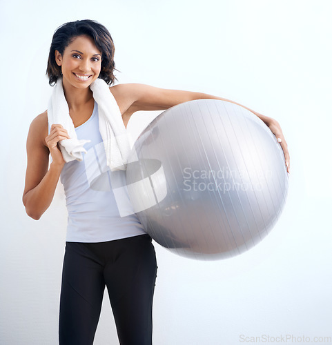 Image of Black woman, exercise ball and smile in studio for fitness, training or workout with towel on white background. Person, portrait and happiness with equipment for wellness, pilates or yoga on mock up