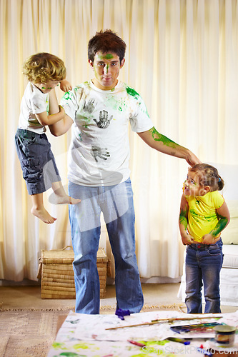 Image of Family, paint and messy children on dad, childhood and crazy in living room at home, bad and naughty. Father and kids, painting and art on clothing, energy and punishment for behavior by tired man