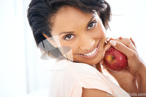 Image of Health, apple and portrait of woman in a studio for wellness, nutrition and organic diet. Smile, vitamins and happy young female person eating a fruit for healthy vegan snack by white background.