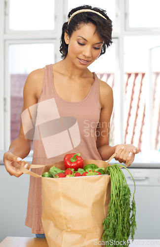 Image of Kitchen, vegetables and woman with groceries, healthy food and wellness with retail, package and customer. Person, client and girl with nutrition, home and meal with brown bag, thinking and diet