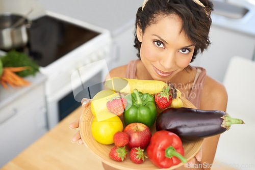 Image of Portrait, health and vegetables with a woman in the kitchen of her home for nutrition, diet or meal preparation. Face, ingredients and a recipe for cooking food with a young person in her apartment