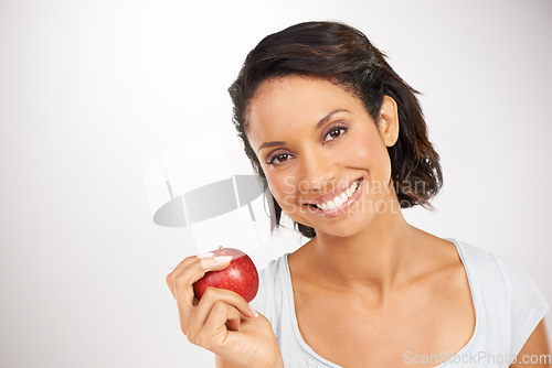Image of Happy woman, portrait and apple for health diet, snack or natural nutrition against a studio background. Face of female person or model smile with red organic fruit for fiber, vitamin or healthy meal
