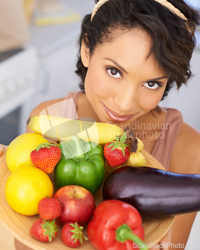 Image of Portrait, food and vegetables with a woman in the kitchen of her home for nutrition, diet or meal preparation. Face, health and recipe ingredients for cooking with a young person in her apartment