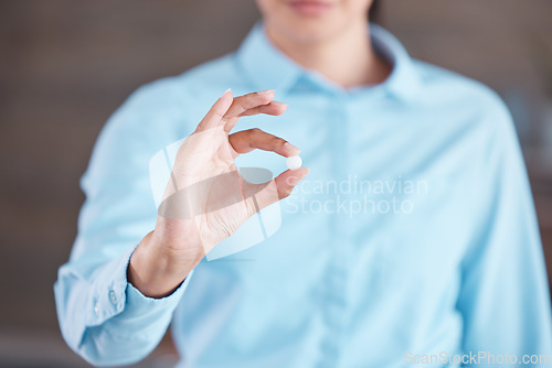 Image of Closeup of female hands holding pill. Business woman going to take tablet for headache, holding painkiller medication