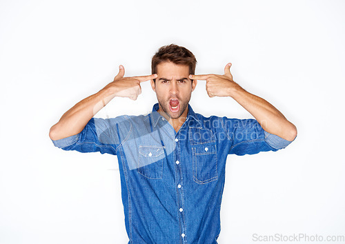 Image of Portrait, fashion and finger gun with a crazy man in studio isolated on a white background for expression. Mental health, anger and a young model pointing to his temple to gesture a mind blown emoji