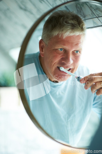 Image of Mirror, cleaning or mature man brushing teeth with dental toothpaste for oral hygiene grooming in home. Face reflection, morning or senior person with a toothbrush for care, wellness or healthy mouth