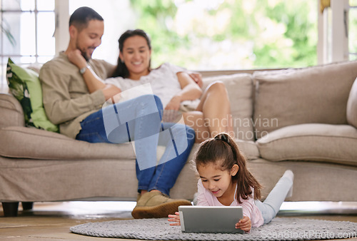 Image of Shes got no worries. a little girl using a digital tablet while relaxing at home.