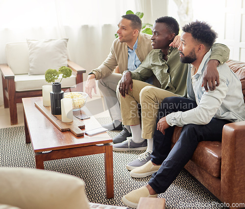 Image of Our team has better luck when we watch the match together. three male friends watching something together while sitting on a couch.