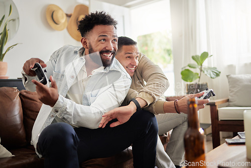 Image of Stop copying my moves. two men playing video games while sitting on a couch together.