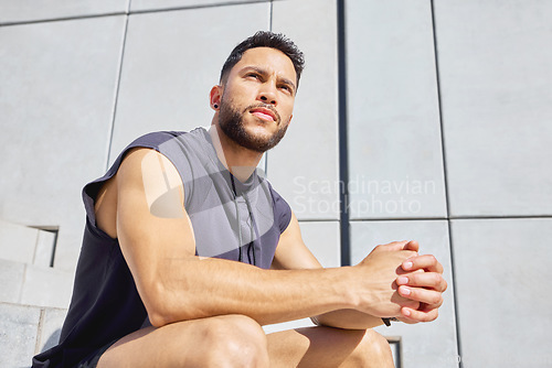 Image of Reset your focus and then try again. Low angle shot of a sporty young man taking a break while exercising outdoors.