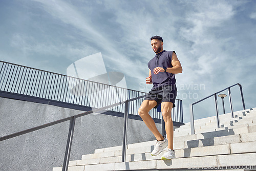 Image of Dont fear moving slowly forward - fear standing still. Low angle shot of a sporty young man running down a staircase while exercising outdoors.