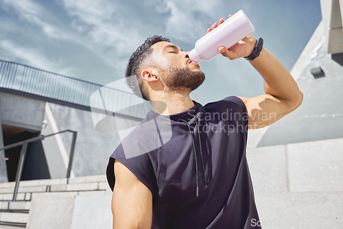 Image of Take breaks so you dont overwork yourself. a sporty young man drinking water while exercising outdoors.