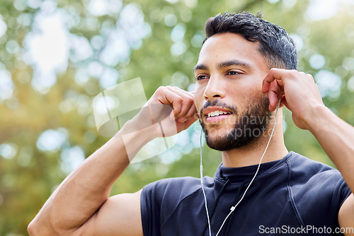 Image of Music can elevate your mood and motivate you. a sporty young man listening to music while exercising outdoors.
