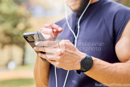 Image of First step is to get my playlist in check. Closeup shot of an unrecognisable man wearing earphones and using a cellphone while exercising outdoors.