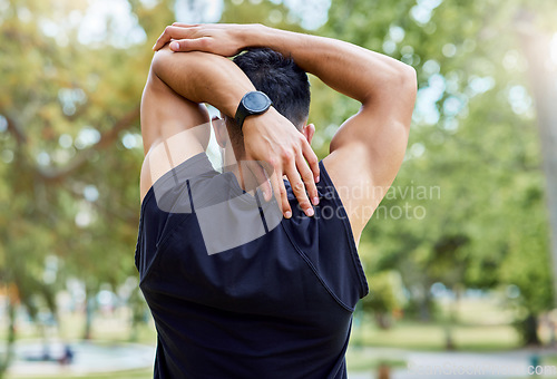Image of Your risk for injury increases if you dont stretch. Rearview shot of a sporty young man stretching his arms while exercising outdoors.
