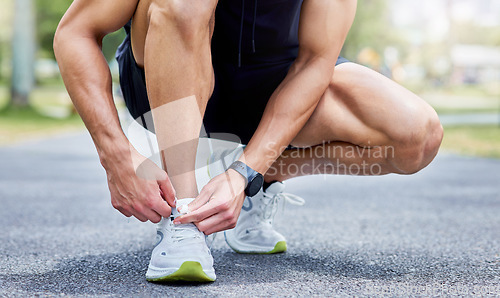 Image of Lace up and give it your all. Closeup shot of an unrecognisable man tying his laces while exercising outdoors.