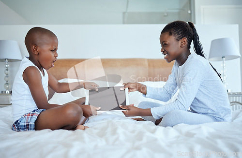 Image of Sibling wars. two siblings fighting in a game of tug of war over their digital tablet.