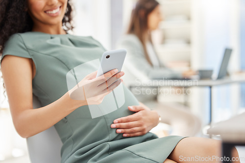 Image of Im getting so many congratulatory texts. Closeup shot of a pregnant businesswoman using a cellphone in an office.