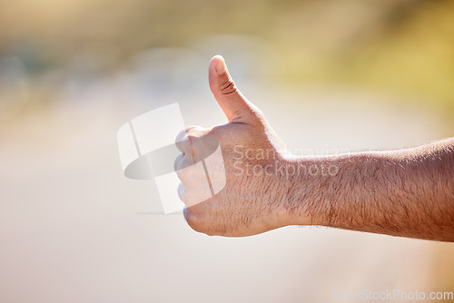 Image of I just need to get out of here. Closeup shot of an unrecognisable man showing thumbs up outdoors.