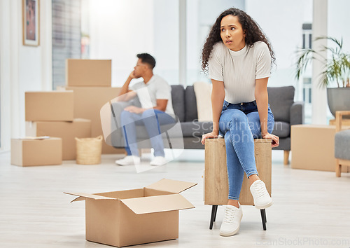 Image of When things dont go right, go left. a young woman looking worried while unpacking boxes in her new house.